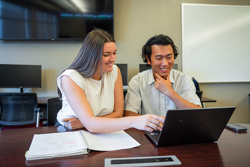 a male student and a female student reviewing their work at a desk