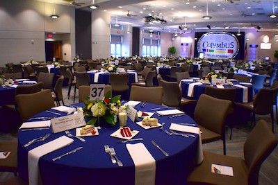 covered circular tables with floral centerpieces