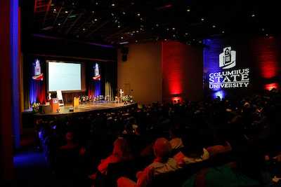 dark auditorium, people on stage